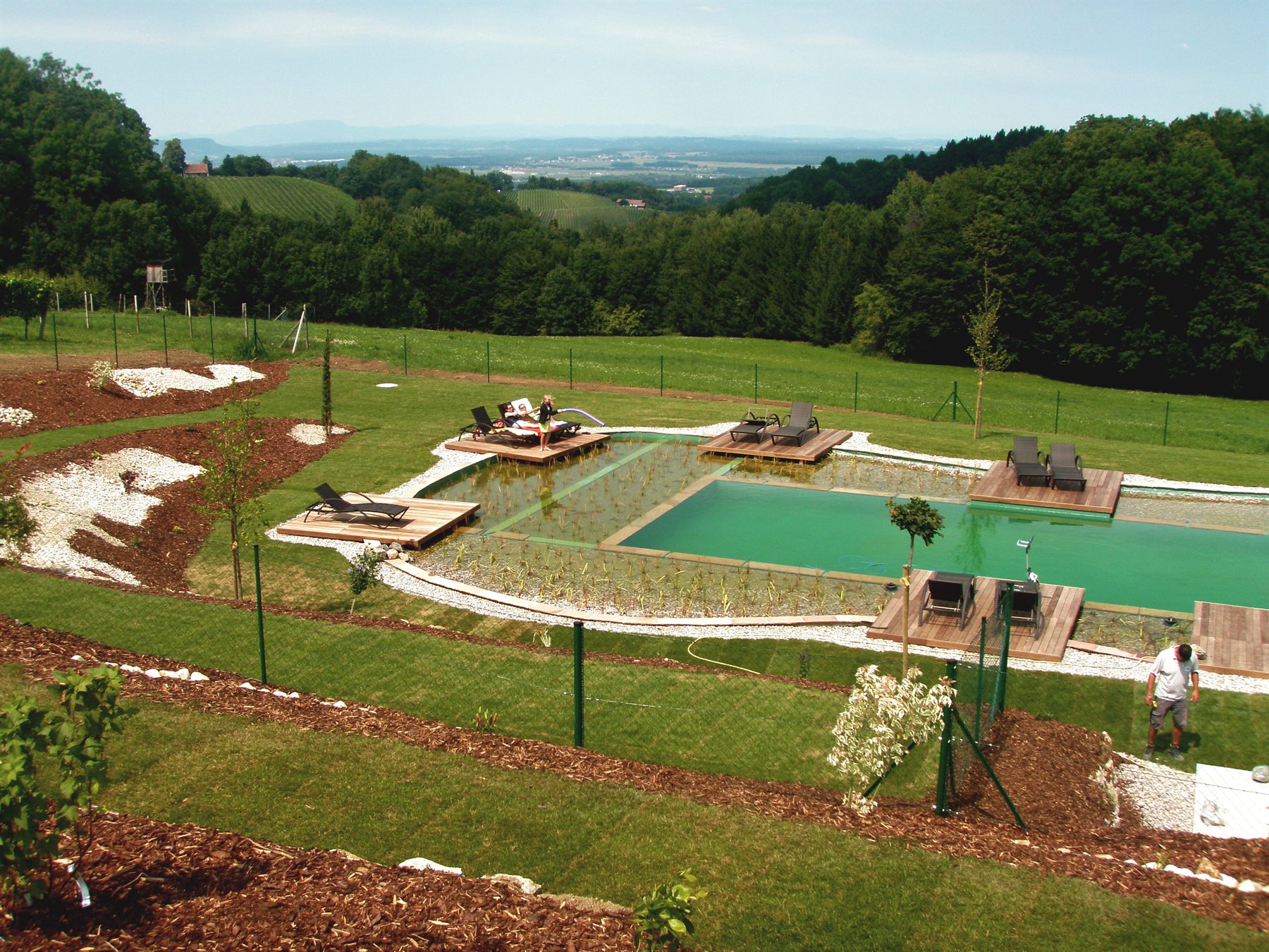 Hotel Naturpool mit Holzinseln und Landschaftsblick